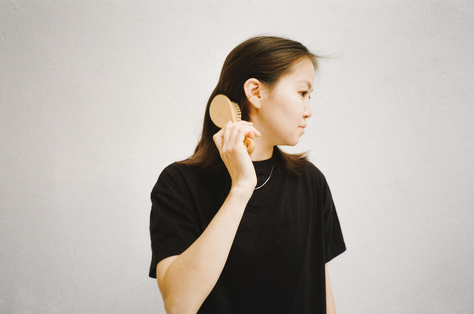 Asian woman brushing hair, hair disorder assessment Dubai