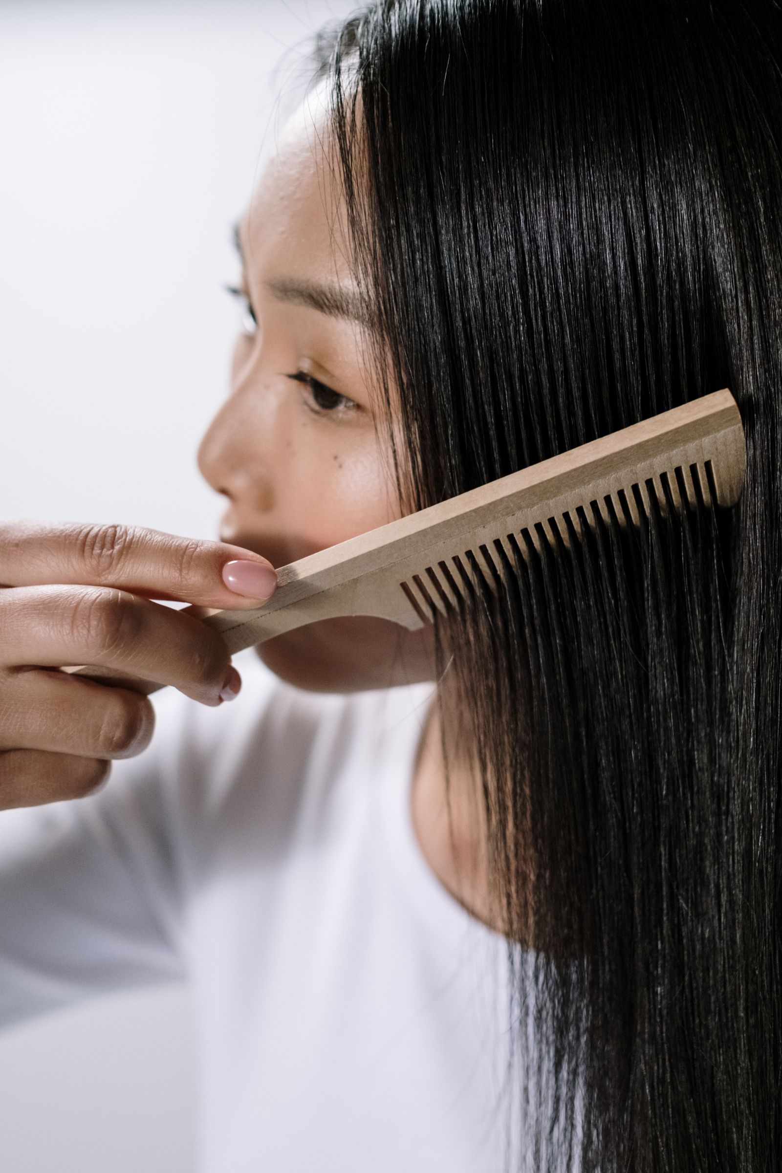 Asian woman combing hair, hair restoration Dubai